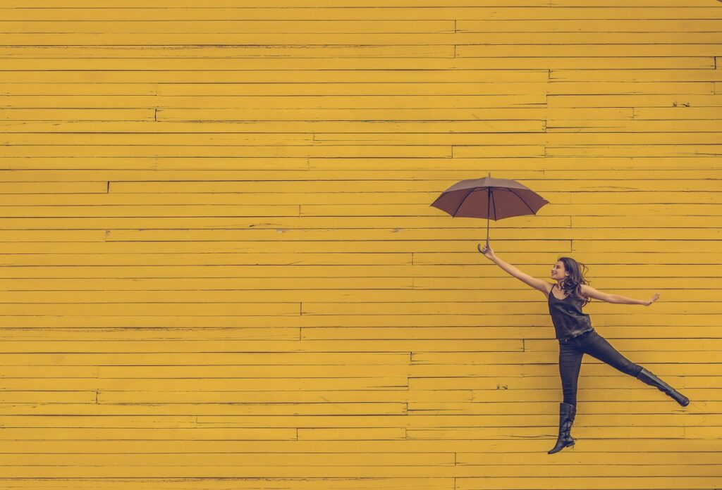 Kobieta z parasolem na żółtym tle